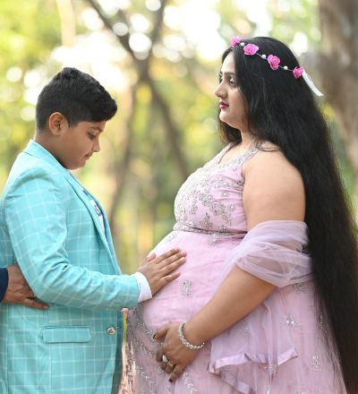 "Heartwarming maternity photoshoot with expecting mother and child bonding, captured by SK Photographer Ranchi in natural outdoor light."
