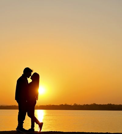 "Romantic pre-wedding couple silhouette at sunset by the riverside, captured by SK Photographer Ranchi, dreamy sunset couple shoot."
