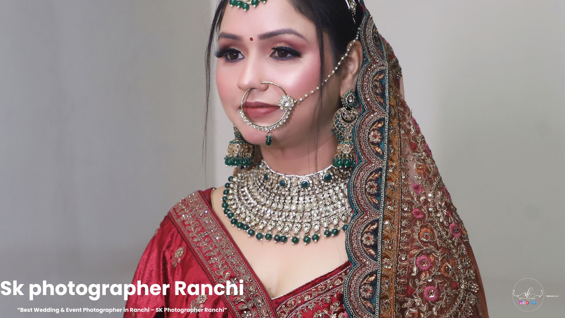 Bridal portrait of an Indian bride in red lehenga with emerald jewelry by SK Photographer Ranchi.