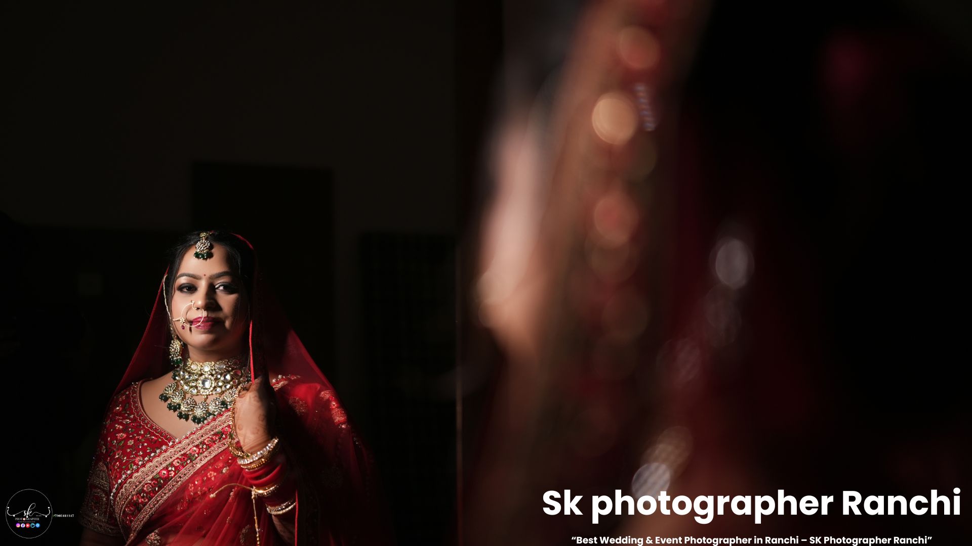 Indian bride in traditional red bridal attire with emerald jewelry, captured in dramatic lighting by SK Photographer Ranchi.