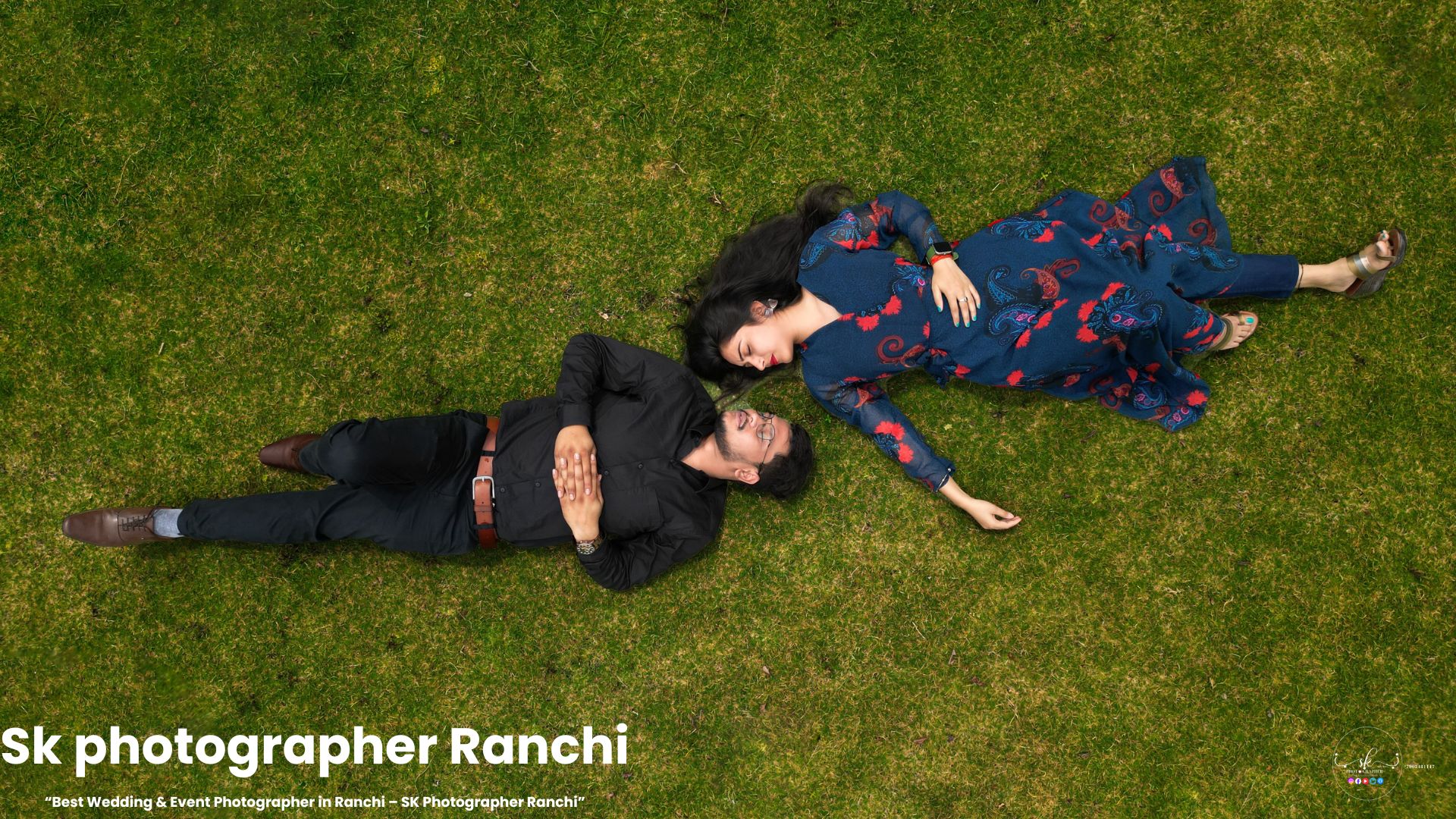Romantic couple lying on grass holding eye contact, captured by a prewedding photographer in Ranchi from a top-angle perspective.